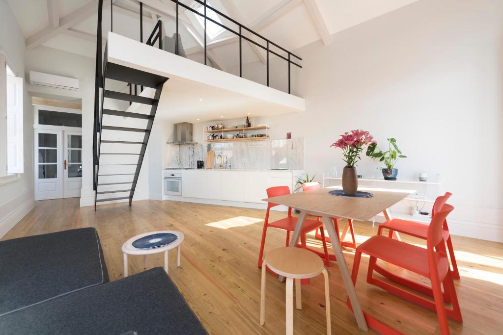 ポルトにあるBmyGuest - Porto Design Central Apartmentのテーブルと椅子、ロフトが備わる客室です。