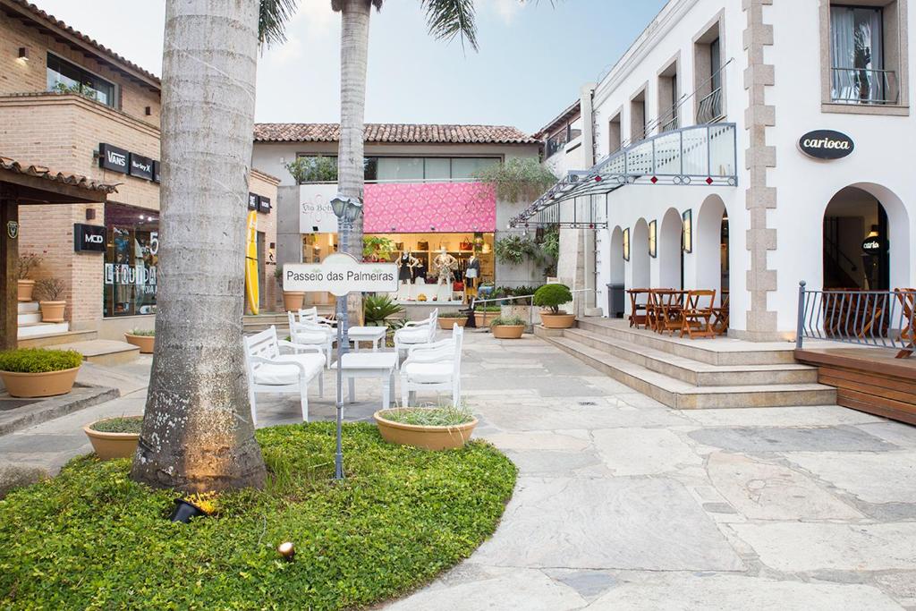 una calle con sillas y un cartel en un patio en Passeio das Palmeiras en Búzios