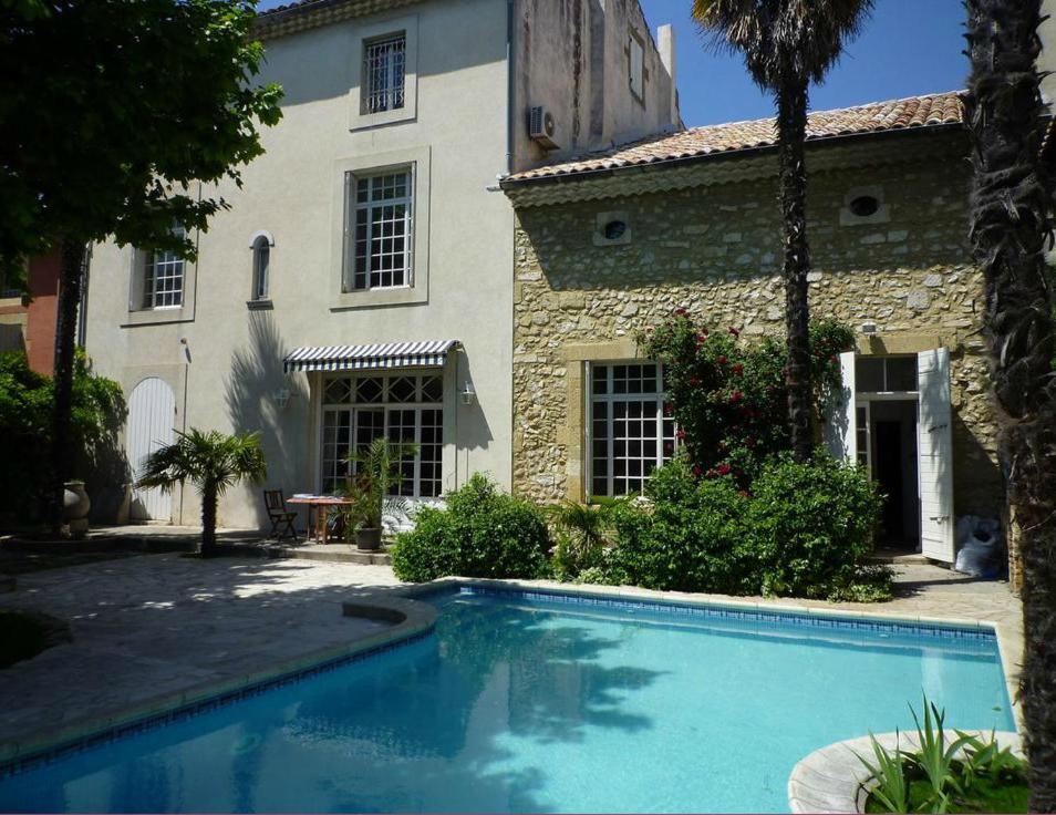 a house with a swimming pool in front of a building at Les Chambres d'hôtes de Luneil (B&B) in Roquemaure