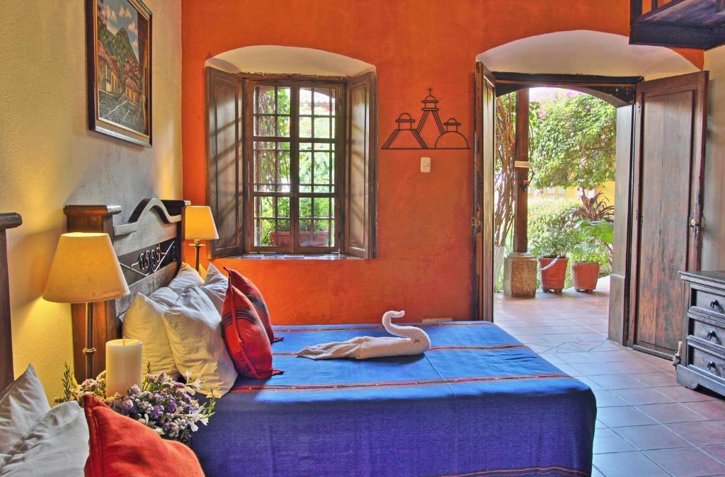 
a room with a bed, a table, and a window at Hotel Casa Antigua by AHS in Antigua Guatemala

