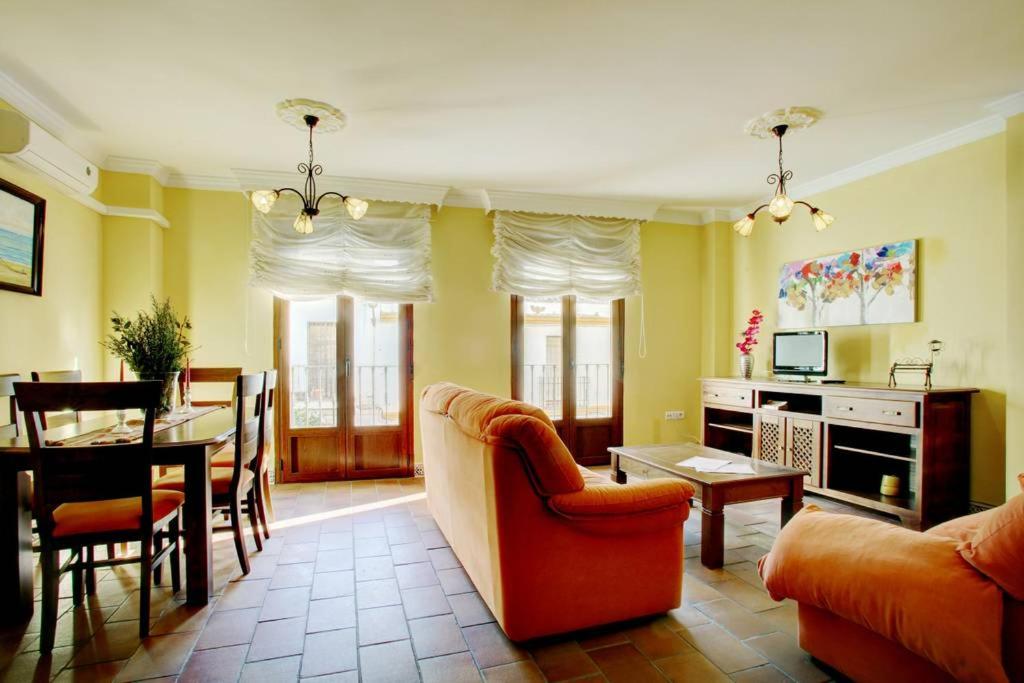 a living room with a couch and a dining room at Apartamento dúplex centro con garaje gratuito in Ronda