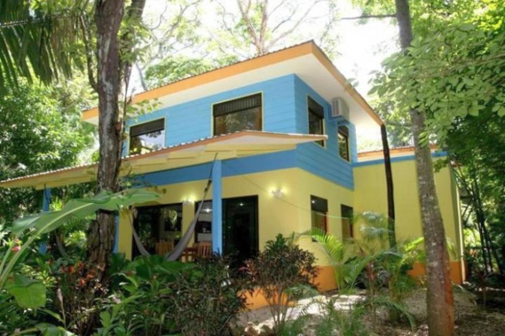 una casa blu e gialla nella foresta di Nosara Paradise Rentals a Nosara