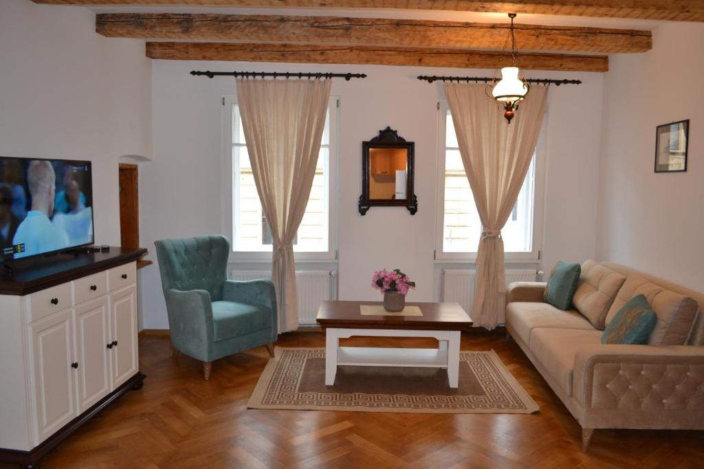 een woonkamer met een bank, een stoel en een tv bij Casa Fanarilor in Braşov