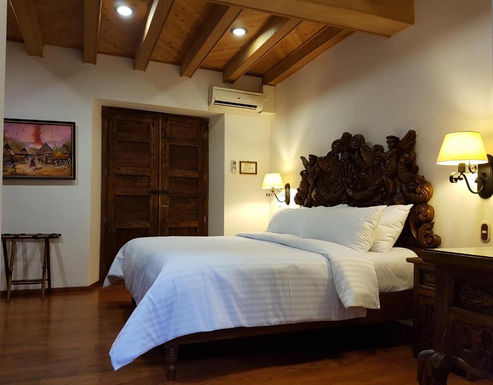 a bedroom with a large bed with a wooden headboard at Hotel Mi Solar Centro in Uruapan del Progreso