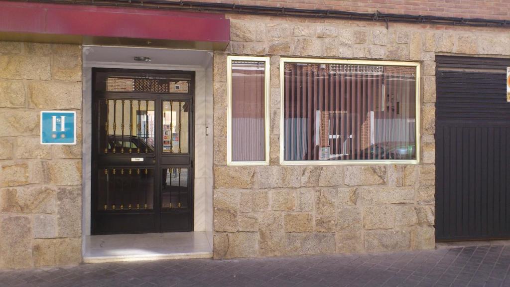 un edificio de ladrillo con puerta y ventana en Hostal Juanito en Móstoles
