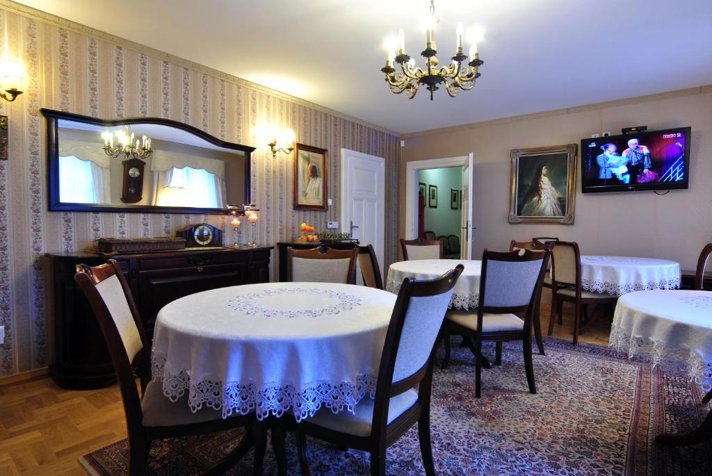 a dining room with tables and chairs and a mirror at Dworek Ojca Mateusza in Sandomierz