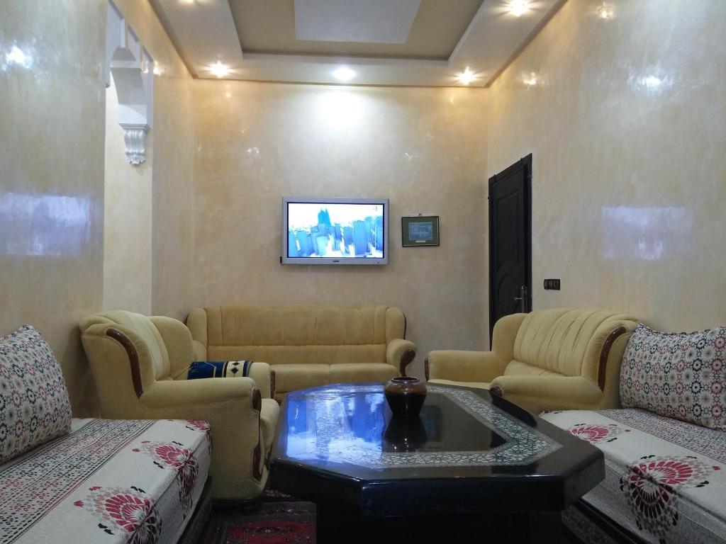 un soggiorno con divani e TV a parete di Appartement Bader a Marrakech