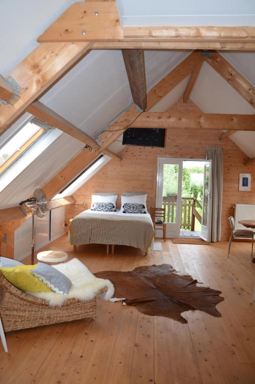 een slaapkamer met een bed in een kamer met houten plafonds bij B&B Nieuwe Brug in Vijfhuizen