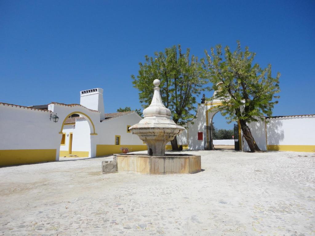 une fontaine dans une cour en face d'un bâtiment dans l'établissement Monte da Amoreira, à Elvas
