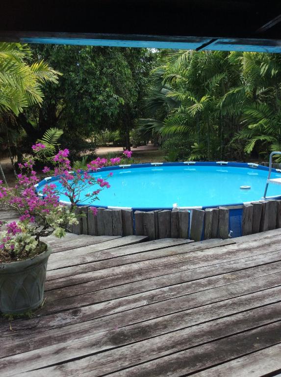 una gran piscina con una terraza de madera y flores en Bamboe en Meerzorg