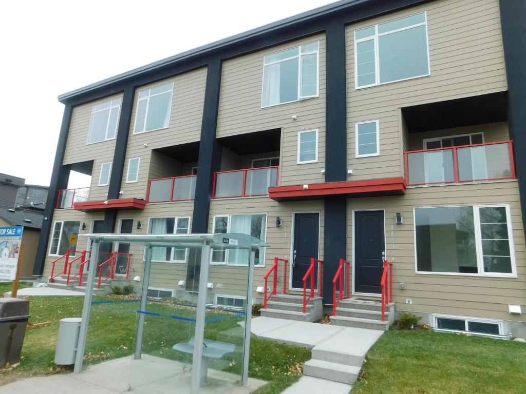 an apartment building with red railing and stairs in front at 3 Bedroom House #37, Sunalta Downtown in Calgary