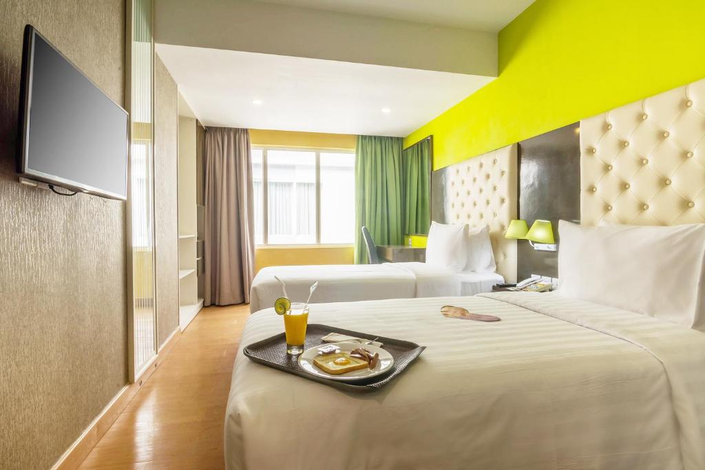 Postel nebo postele na pokoji v ubytování MaxOneHotels at Resort Makassar