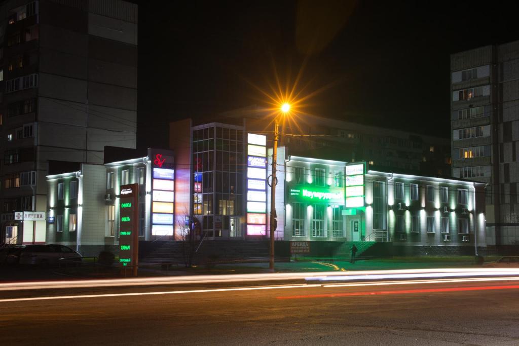 a lit up building at night with a street light at SV Hotel in Biysk