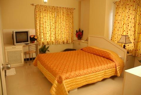 1 dormitorio con 1 cama y TV. en The Corporate Comforts, en Bangalore