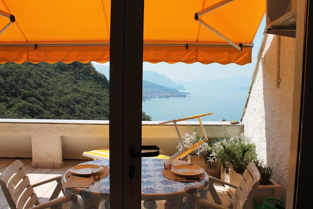 un tavolo e sedie su un balcone con vista sull'oceano di Terrazza sul Lago a Luino