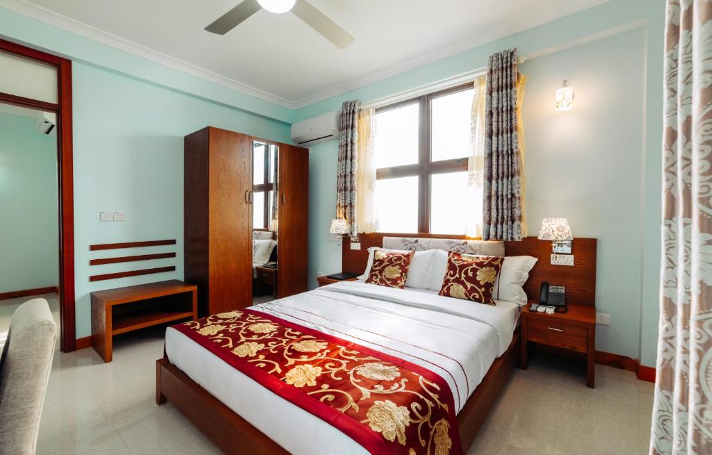 Hithadhoo的住宿－利基戴酒店，一间卧室设有一张大床和一个窗户。