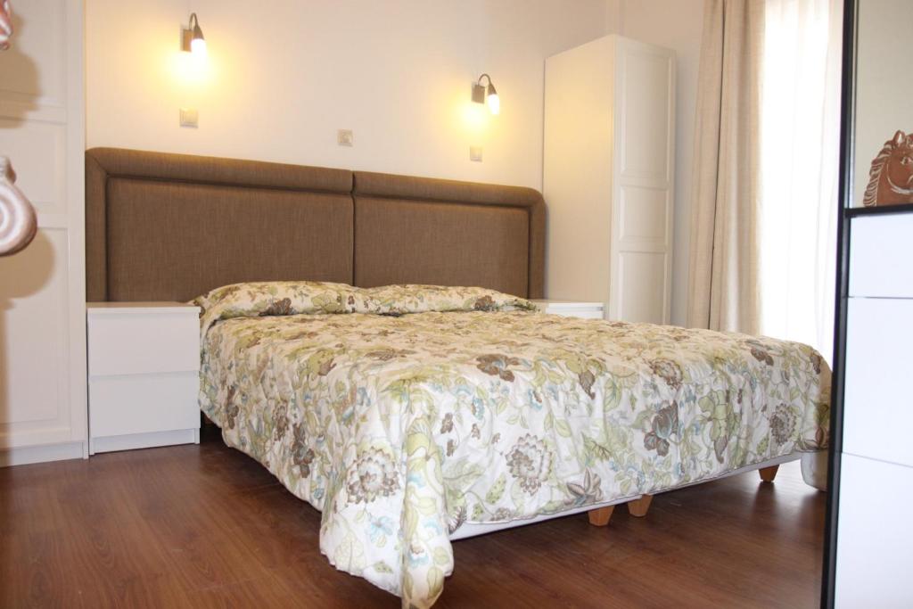 una camera da letto con un letto con copriletto floreale di Be My Guest Apartment ad Atene