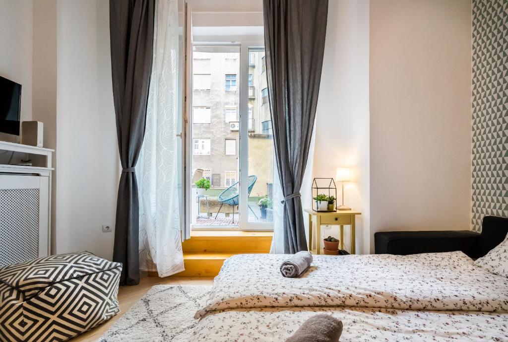 ブダペストにあるMegszűnt - Charming Design Apartment with balconyのベッドルーム1室(ベッド2台、大きな窓付)