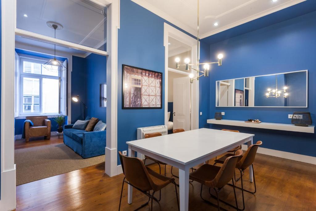 ein Esszimmer mit blauen Wänden sowie einem Tisch und Stühlen in der Unterkunft Baixa Vintage Three-Bedroom Apartment - by LU Holidays in Lissabon