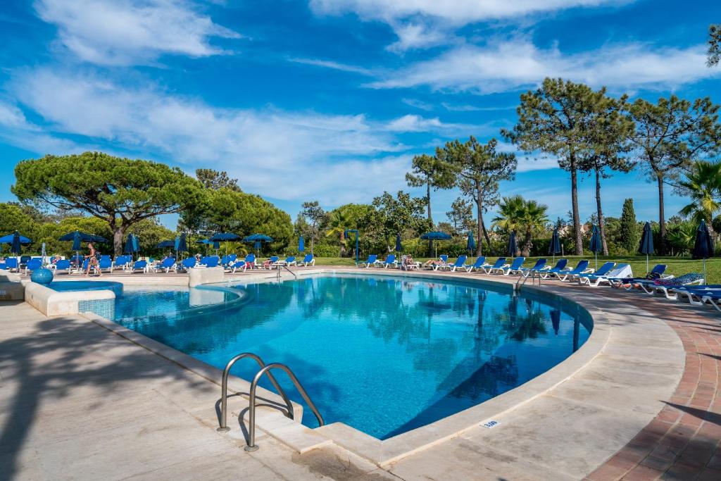 キンタ・ド・ラーゴにあるBmyGuest - Quinta do Lago Terrace Apartment IIの大きなスイミングプール(ラウンジチェア、木付)