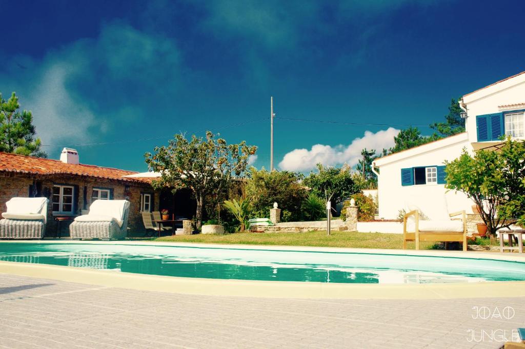 a swimming pool in front of a house at João Jungle in Açafora