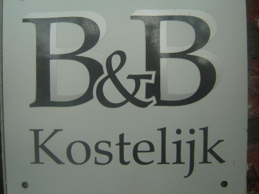 a white sign with the words kosticism on it at B & B Kostelijk in Boekelo
