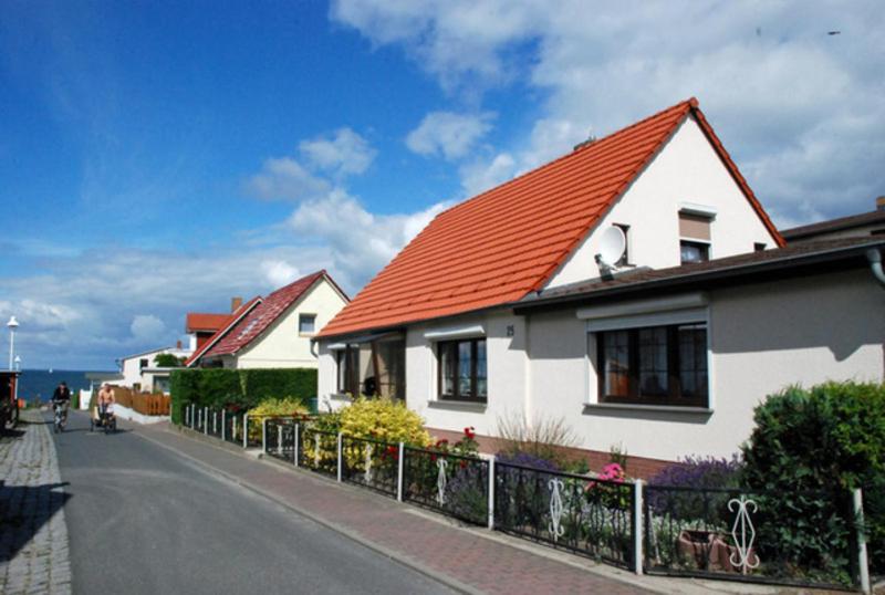 Klein ZickerにあるFerienhaus Christaの通り沿いのオレンジ色の屋根の白い家