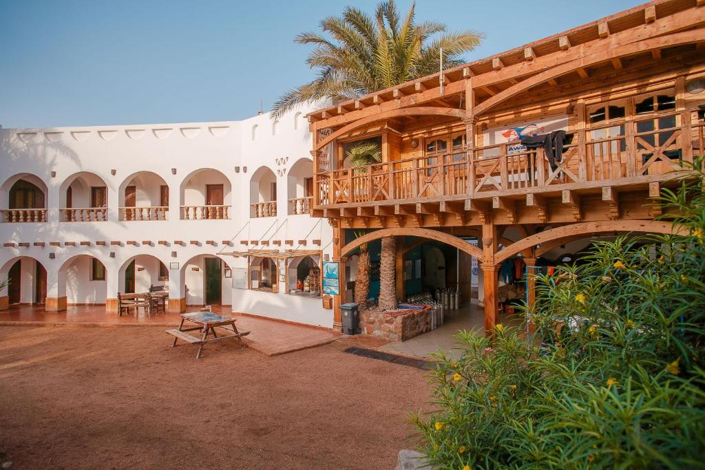 a large building with a walkway leading to a swimming pool at Dahab Divers in Dahab