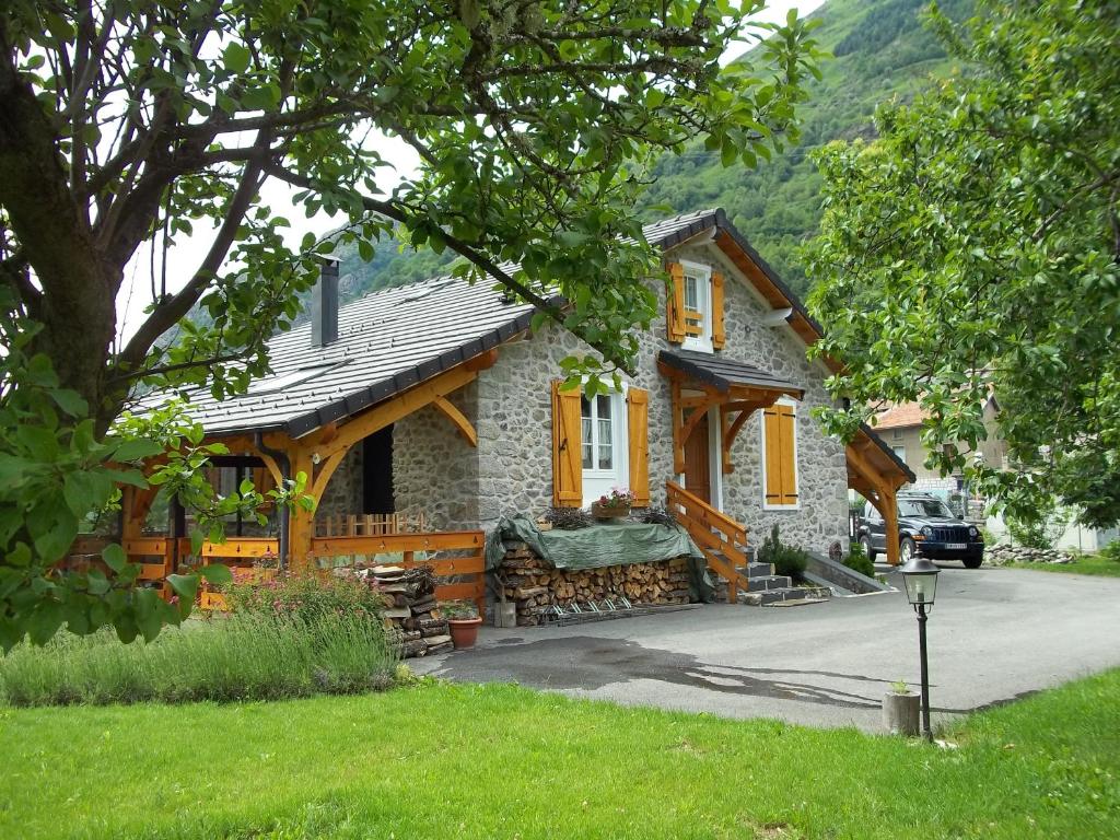 a stone house with yellow windows and a driveway at Ouxis in Orlu