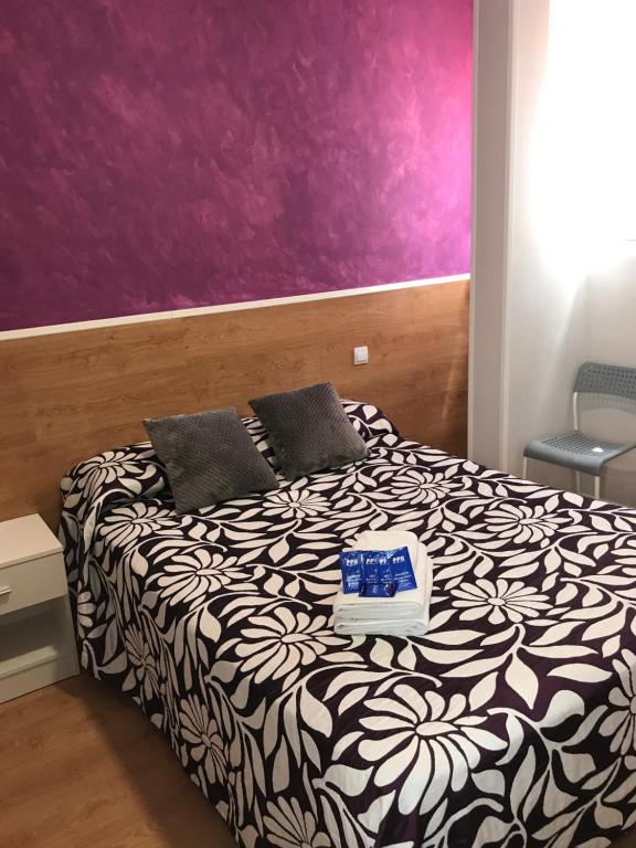 a bedroom with a bed with a purple wall at Casa Huésped Magdalena in Madrid