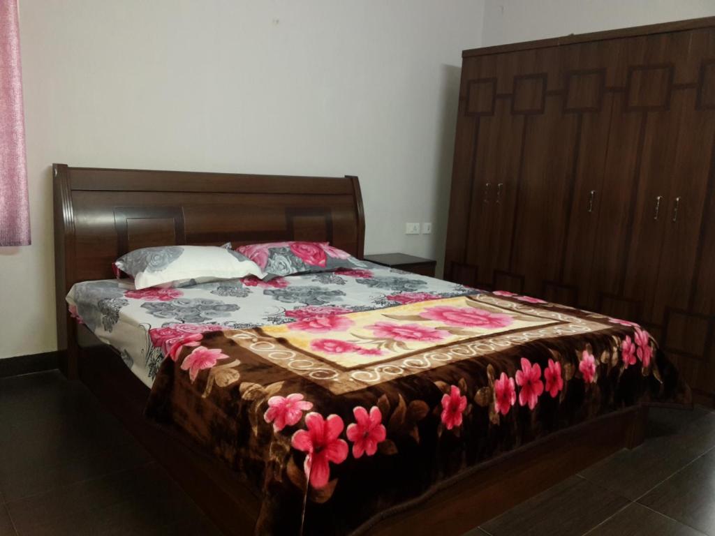 een bed met een dekbed in een slaapkamer bij Holidays and Celebrations in Kodaikānāl