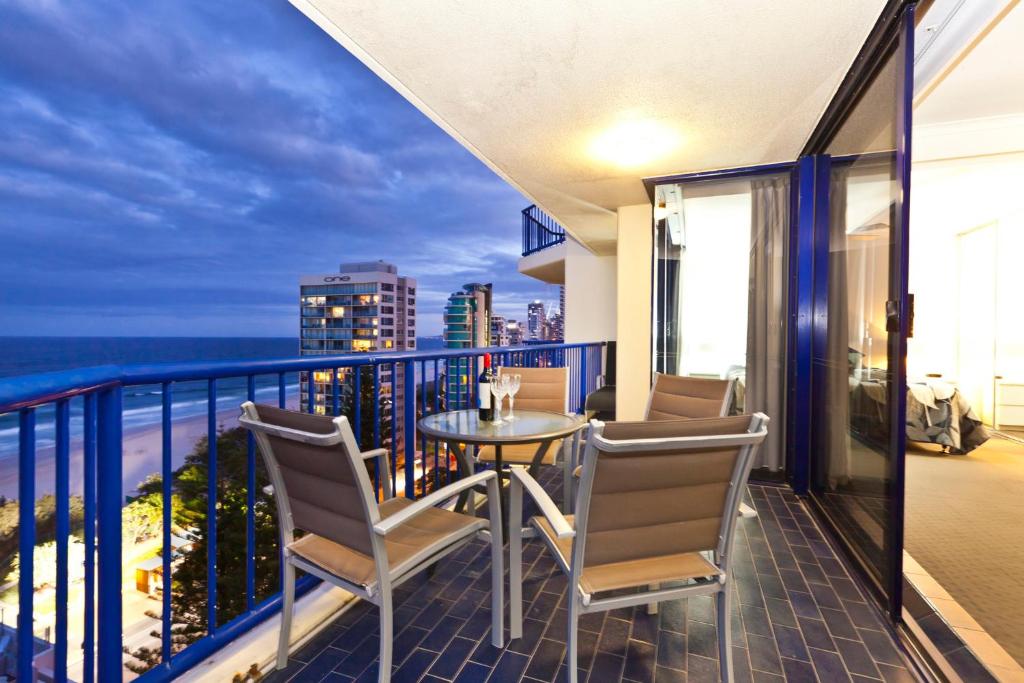balcón con mesa, sillas y vistas al océano en Surf Regency, en Gold Coast