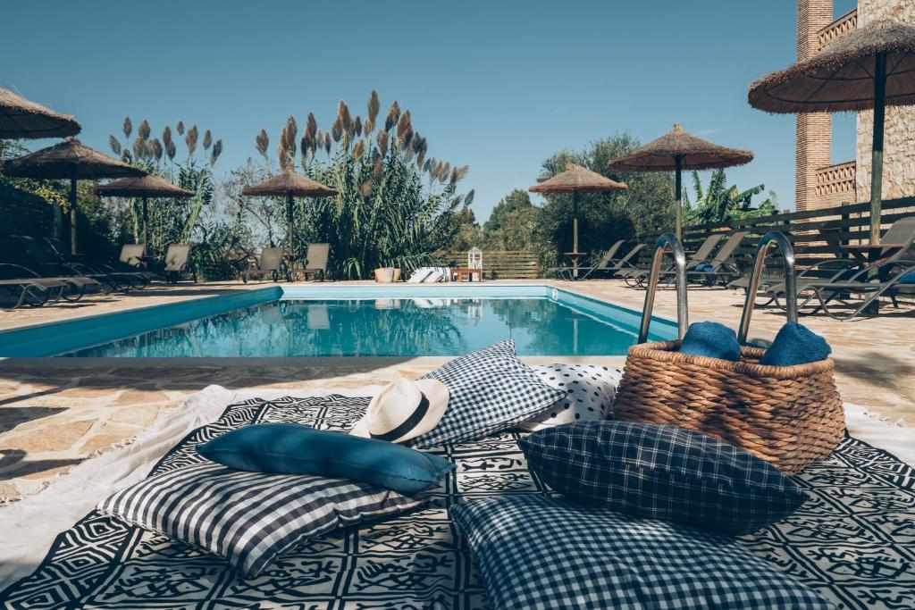 a pool with chairs and umbrellas next to a swimming pool at Alegria Villas Complex in Vasilikos