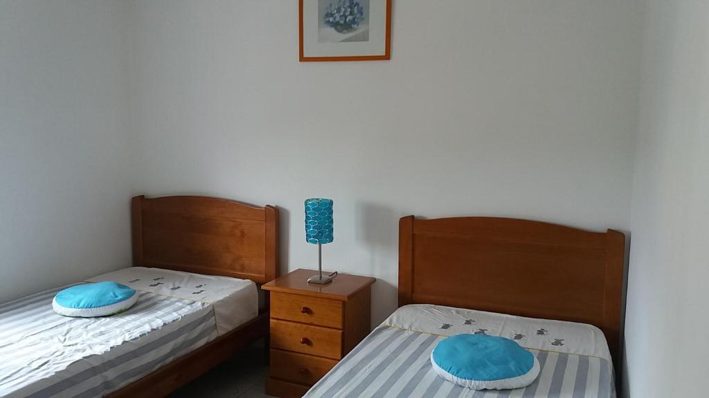 een slaapkamer met 2 bedden en een lamp op een nachtkastje bij Gaivota Sun in Portimão