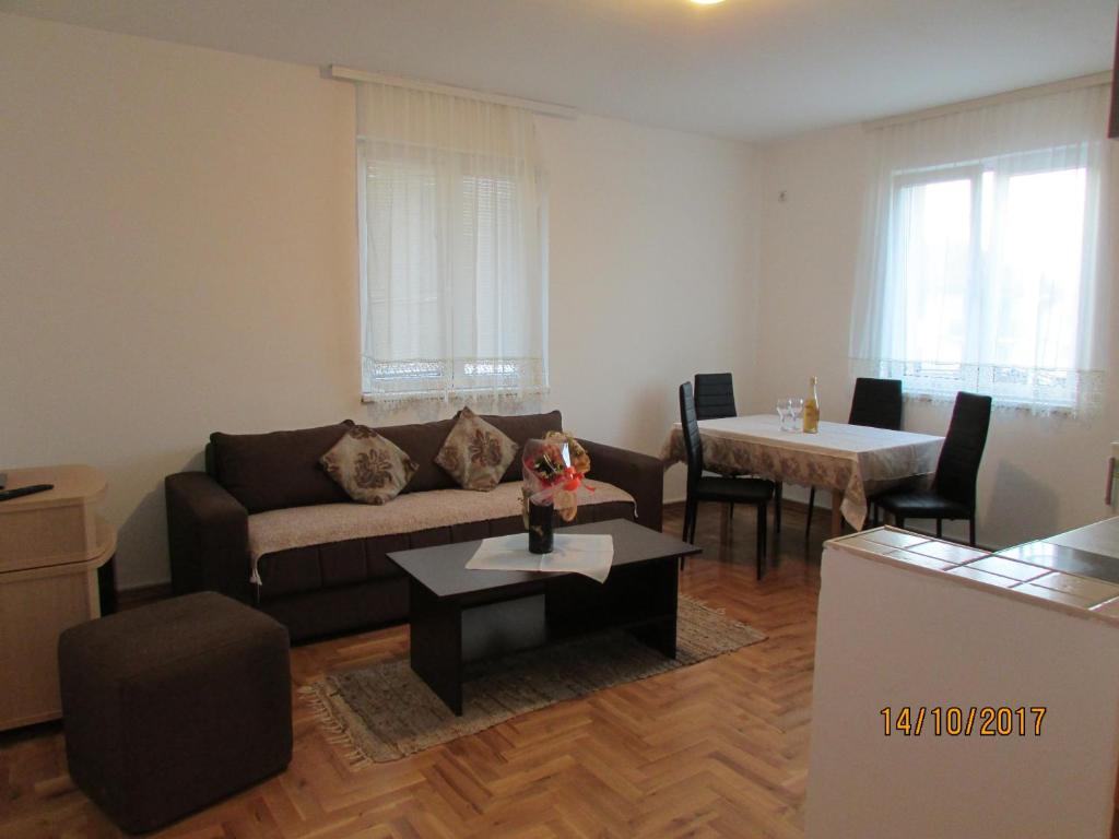 ein Wohnzimmer mit einem Sofa und einem Tisch in der Unterkunft Debora Apartment in Vrnjačka Banja