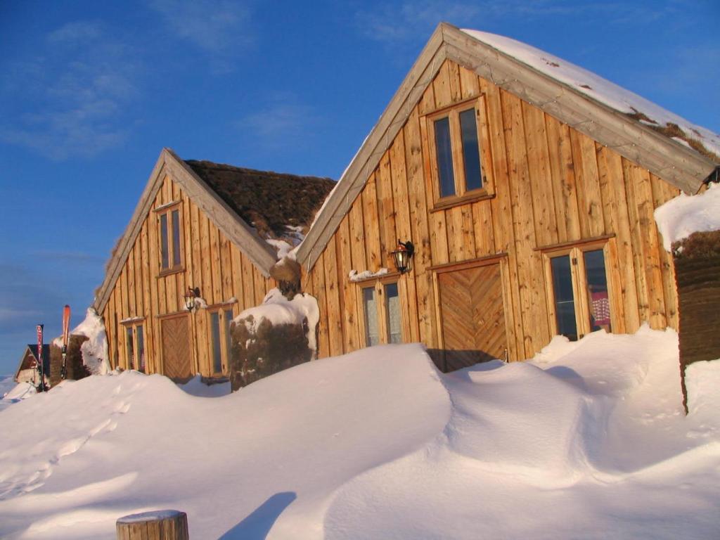 a wooden building covered in snow with snow around it at Fjalladýrð Guesthouse in Modrudalur