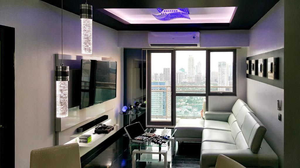 een woonkamer met een bank en een tafel met stoelen bij Modern Luxury Lower Penthouse Unit in Manilla