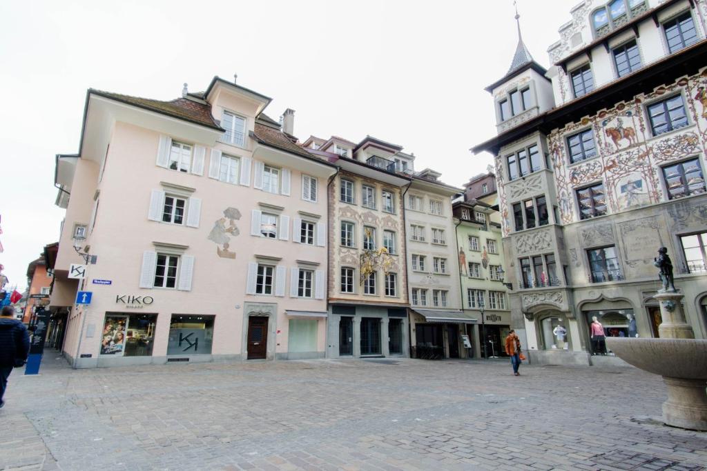 eine Gruppe von Gebäuden auf einer Straße in einer Stadt in der Unterkunft KoBi Apartments Hirschenplatz in Luzern