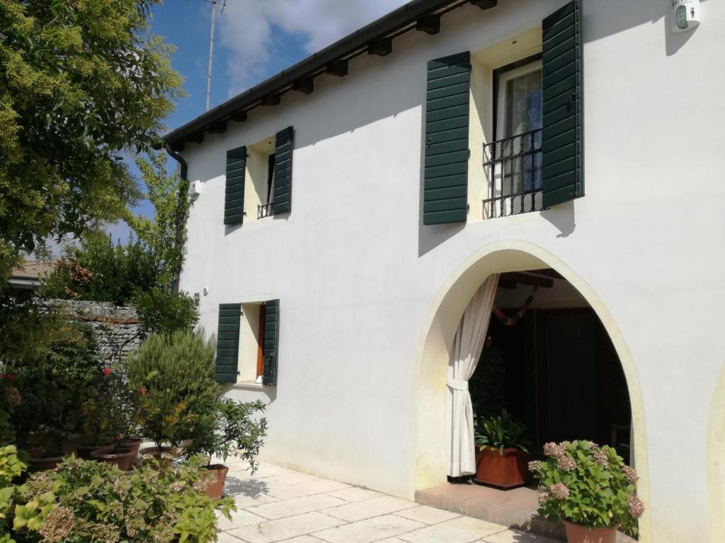 Casa blanca con persianas verdes en B&B LE ORTENSIE, en Castagnole