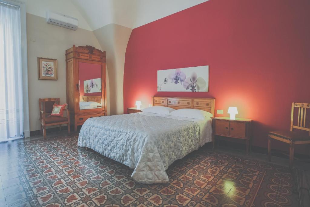 カターニアにあるPalazzo Speciale B&Bの赤い壁のベッドルーム1室(ベッド1台付)