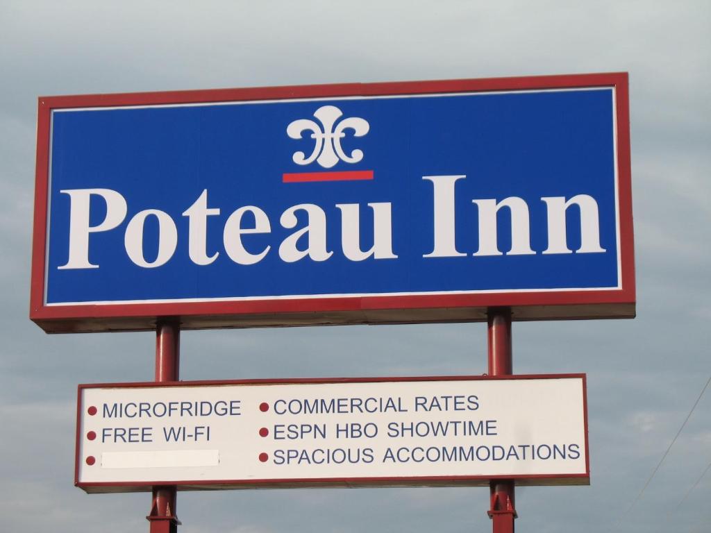een teken voor een pctuim bovenop twee tekens bij Poteau Inn in Poteau