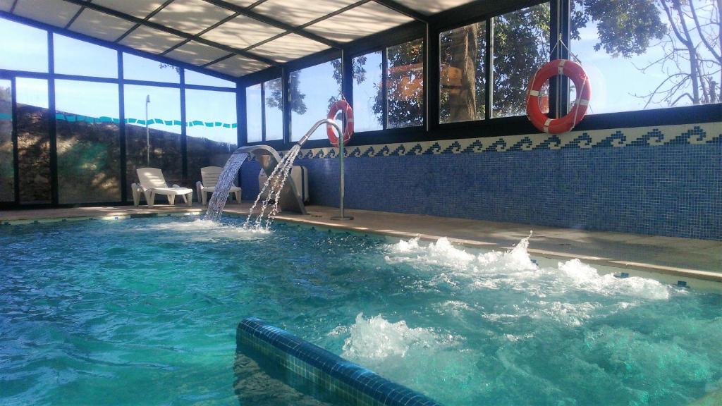 - une piscine avec toboggan dans un bâtiment dans l'établissement Hotel San Millán, à Santander