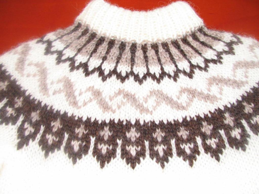 a white sweater with a black and white necklace at Fjalladýrð Guesthouse in Modrudalur
