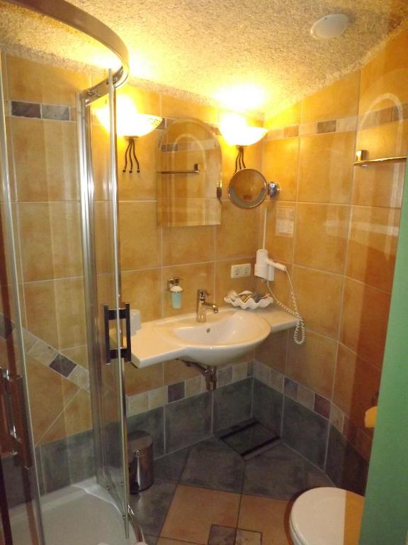 a bathroom with a sink and a shower at Hotel Piccolo in Schleiz