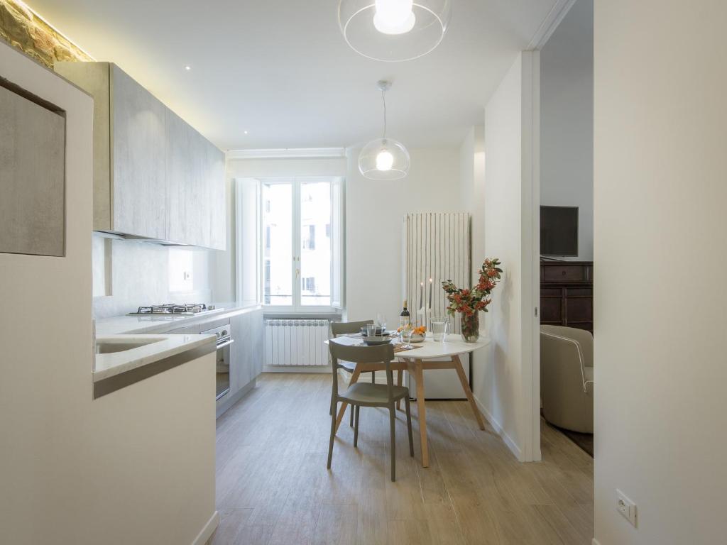 Una cocina con una mesa y un comedor. en San Firenze Luxury Apartment by Mamo Florence, en Florencia