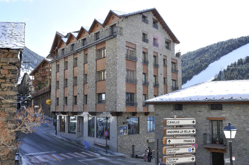 un gran edificio con un cartel delante en Apartaments Turistics Pirineu, en Soldeu