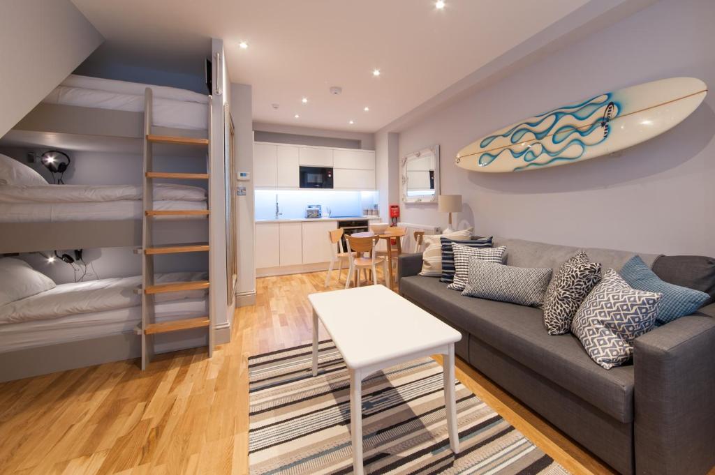 a living room with a couch and a surfboard on the wall at Suites at number Ten in Broadstairs