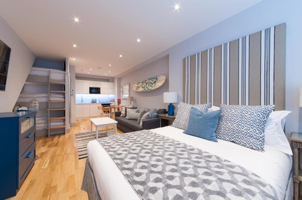 a bedroom with a large bed and a living room at Suites at number Ten in Broadstairs