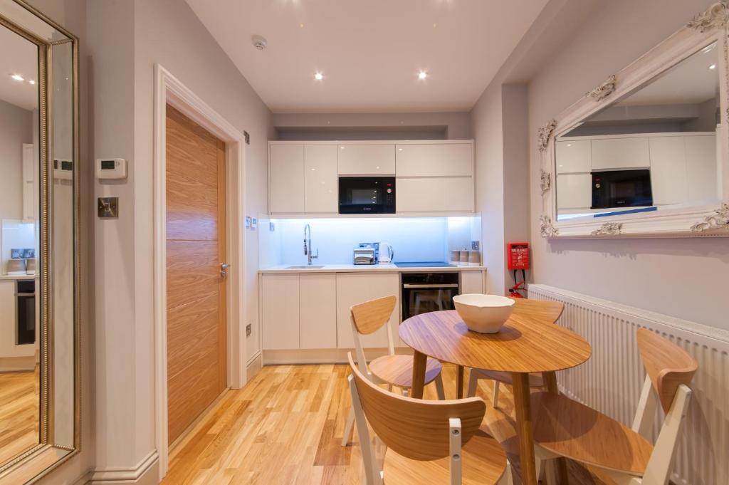 a kitchen and dining room with a wooden table and chairs at Suites at number Ten in Broadstairs