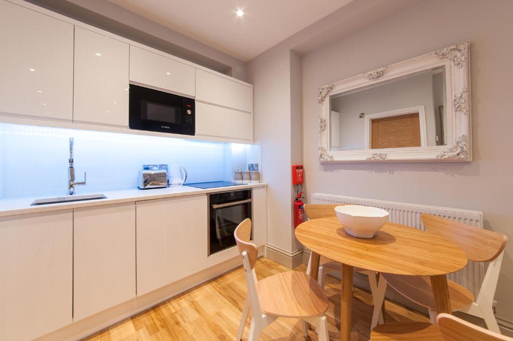 a kitchen with a wooden table and a small dining room at Suites at number Ten in Broadstairs